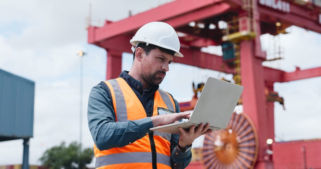 Noise consultant carrying out a site assessment and noise survey using a laptop to review survey data and project requirements